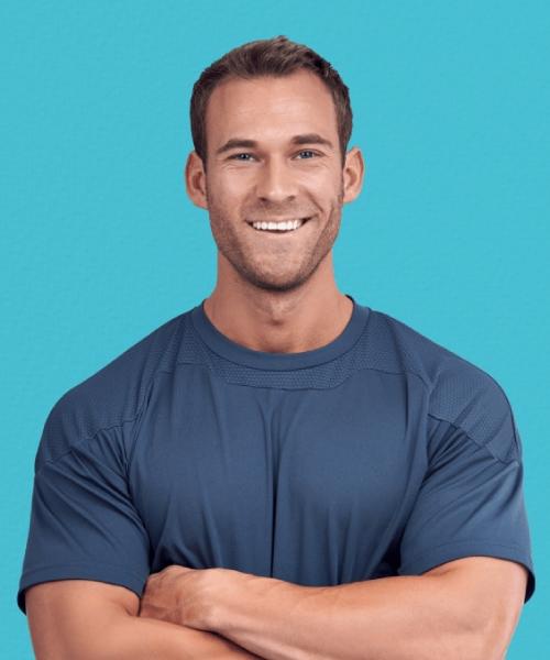 Muscular man with arms crossed smiling | Ethereal Aesthetics